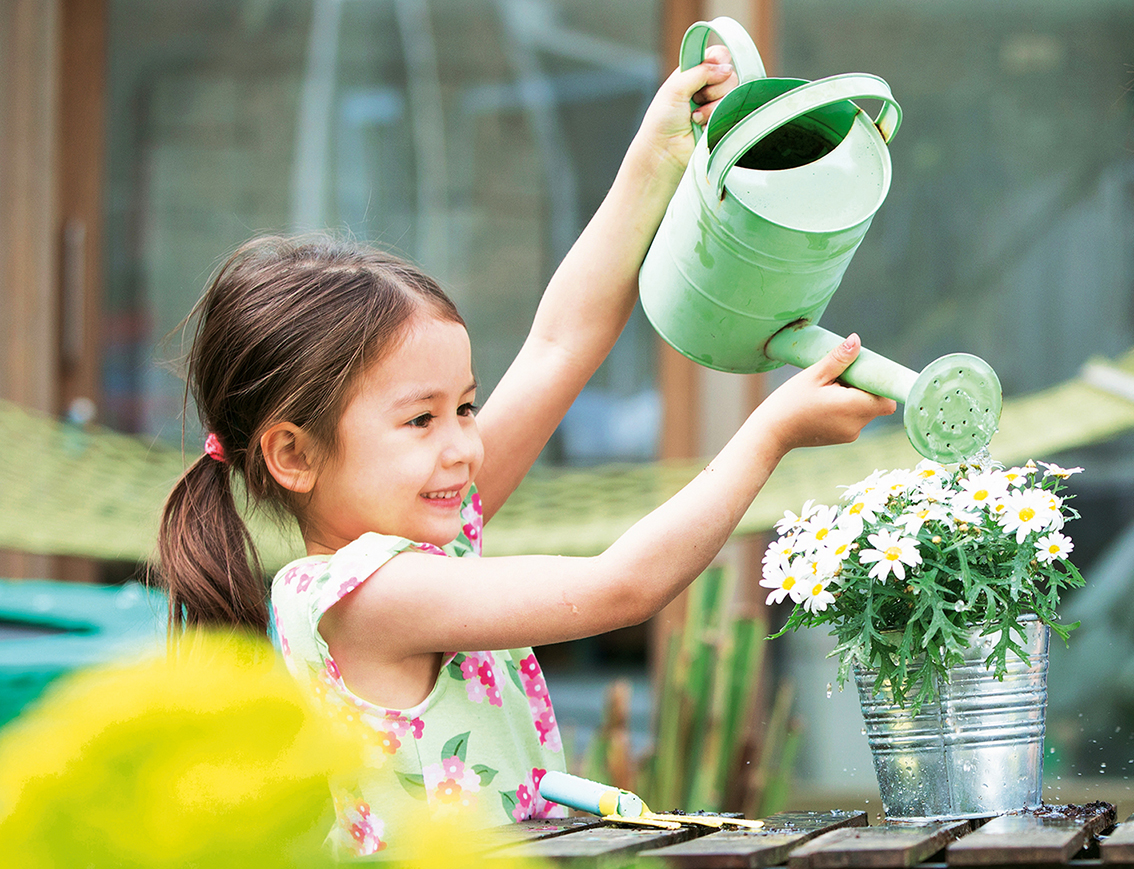 Kind gießt die Blumen