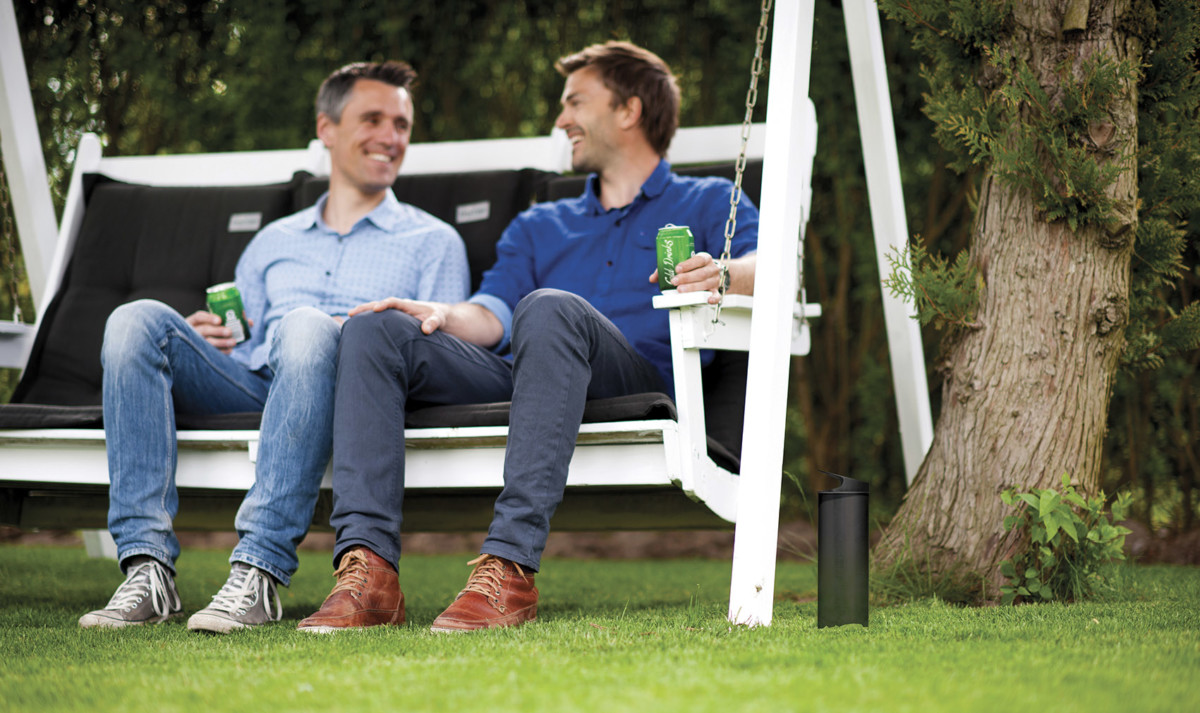 Freunde sitzen mit Getränk im Garten